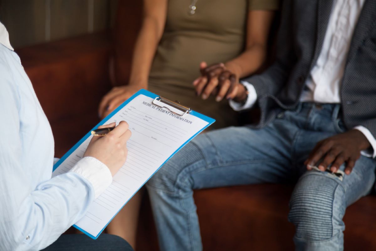 Couple holding hands and discussing infertility with North Houston fertility doctor
